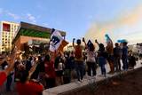 Se observa la llegada del camión de pumas y todos los aficionados al rededor con banderas